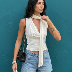 Top de tirantes blanco con pañuelo, pared verde