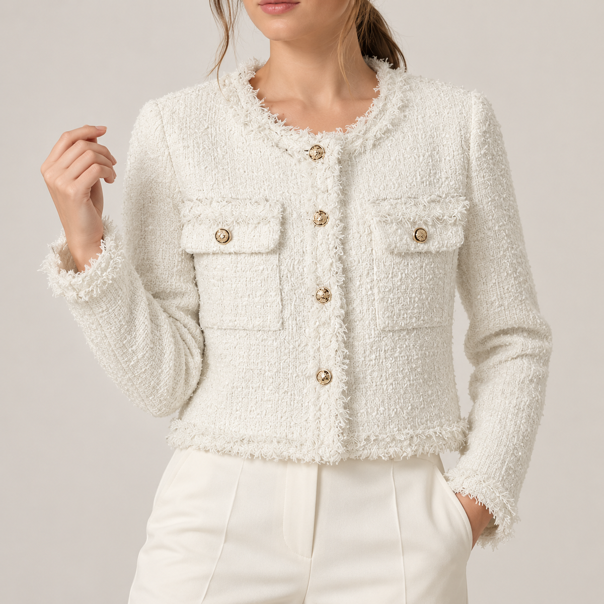 Detalle de chaqueta tweed blanca con flecos y botones dorados